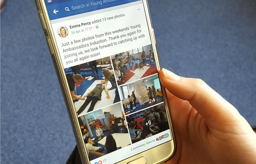 A young adult scrolls through posts in The Brain Tumour Charity's Young Adult Facebook Group using their mobile phone.
