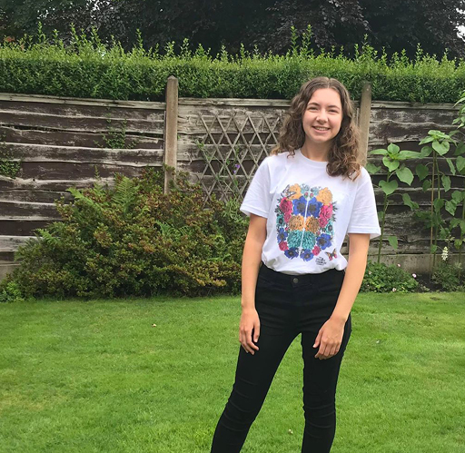Person standing in a garden wearing a Great Minds charity tshirt