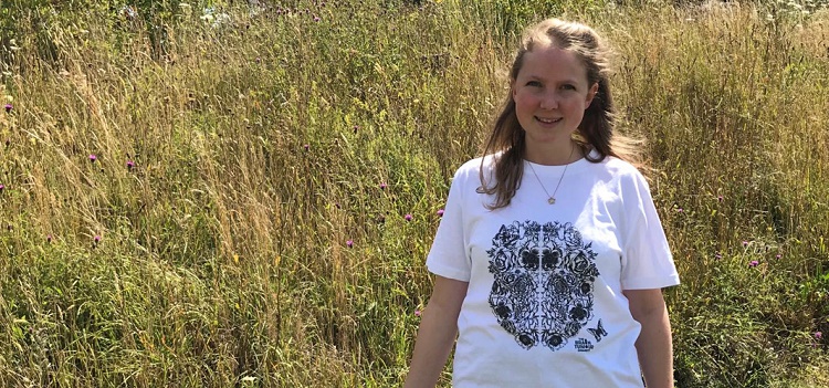 A girl in a field wearing the new Great Minds t-shirt designed for The Brain Tumour Charity
