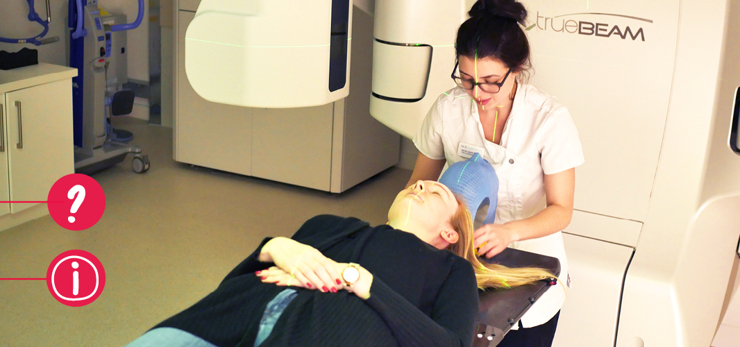 A young woman laying on a hospital gurney being prepared for radiotherapy treatment by a healthcare professional.