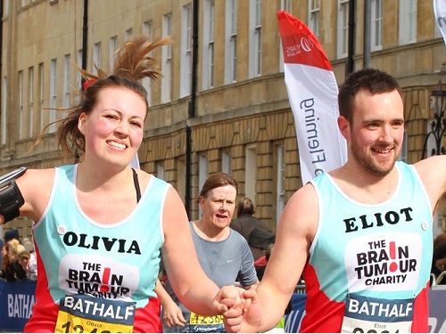 Olivia and Elliot running hand in hand in charity vests